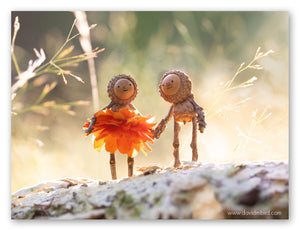 Two Becorns smiling and holding hands against a glowing background. One of the Becorns is wearing an orange mum flower as a dress.